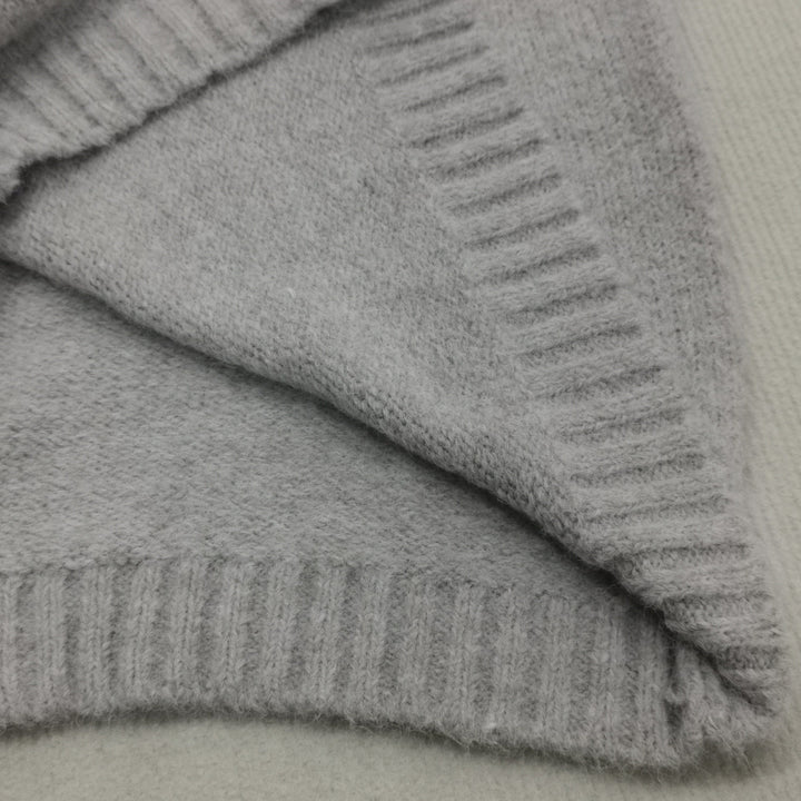 Grauer Kaschmirpullover, weiches Material, Nahaufnahme, Strickmode, luxuriös, warm, elegant.