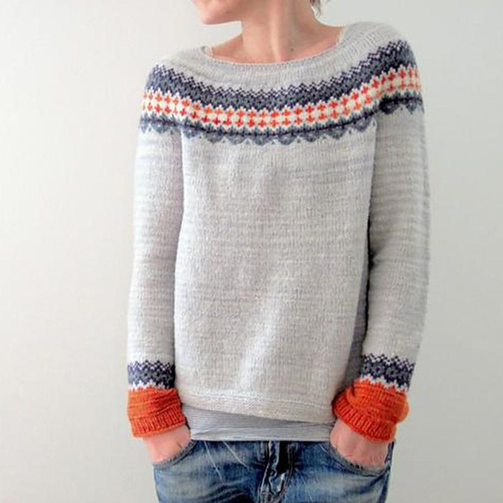 Frau trägt grauen Strickpullover mit buntem Muster, lässiger Stil, Herbstmode, Damenbekleidung.