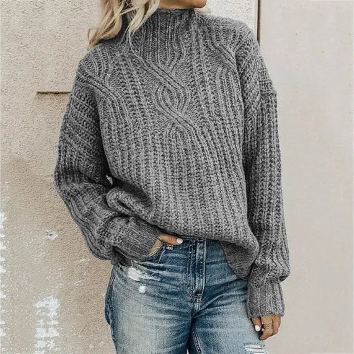 Frau in grauem Strickpullover und Jeans, lässiger Herbstlook, modische Damenbekleidung.