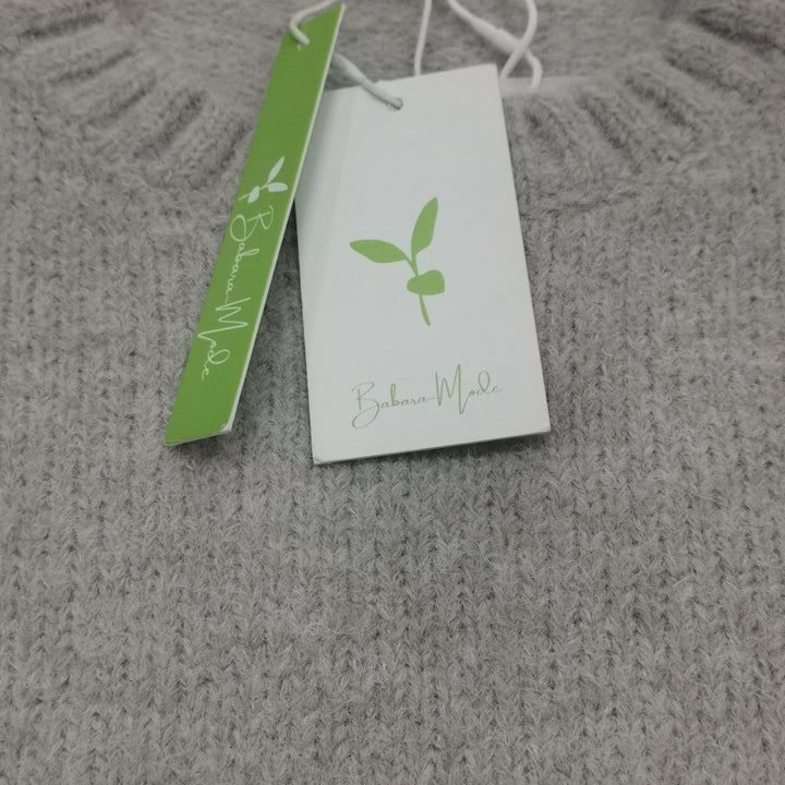 Grauer Strickpullover aus Wolle mit Etikett, nachhaltige Mode, weiches Material, Damenbekleidung.
