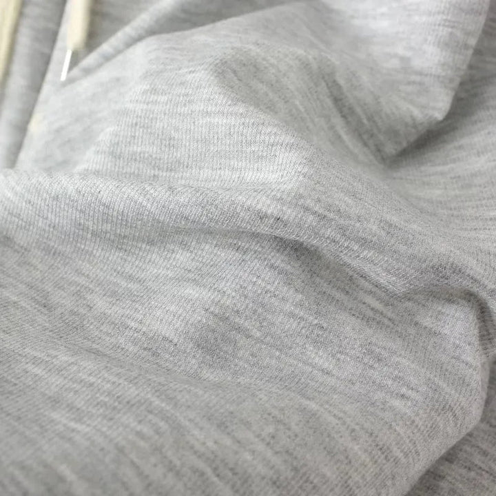 Grauer Baumwollstoff, weiche Textur, ideal für Bekleidung, hochwertiges Material, Nahaufnahme.