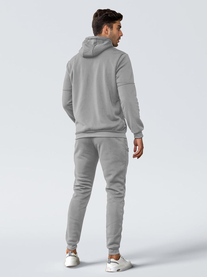 Mann in grauem Jogginganzug, Kapuzenpullover und Jogginghose, sportlich, bequem, Freizeitkleidung.