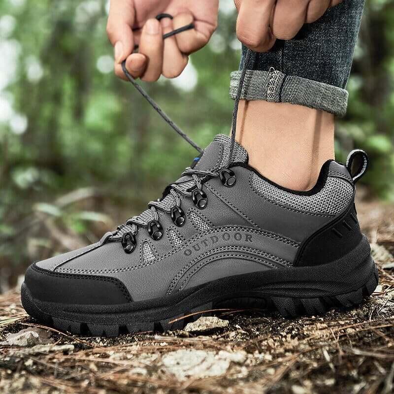 Grauer Wanderschuh aus Leder, Outdoor-Schuhe, robust, rutschfest, ideal für Trekking im Wald.