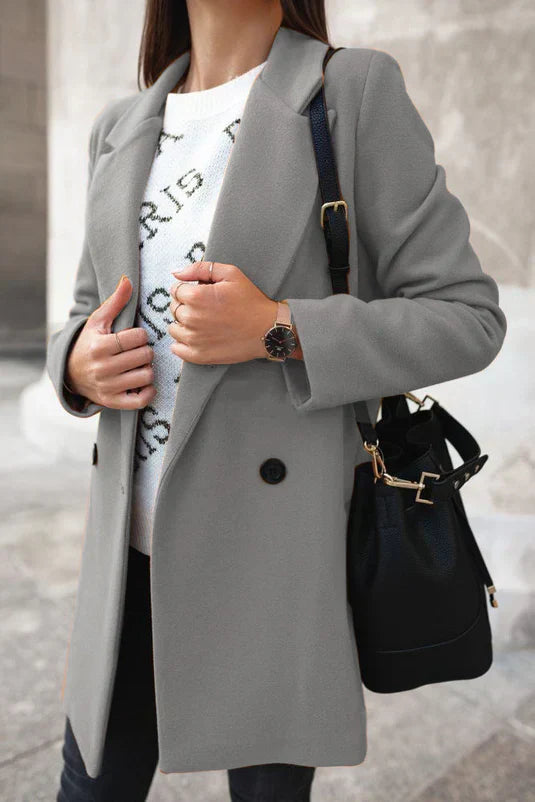 Frau in grauem Mantel mit schwarzer Tasche und Uhr, modisch, elegant, Herbstmode.