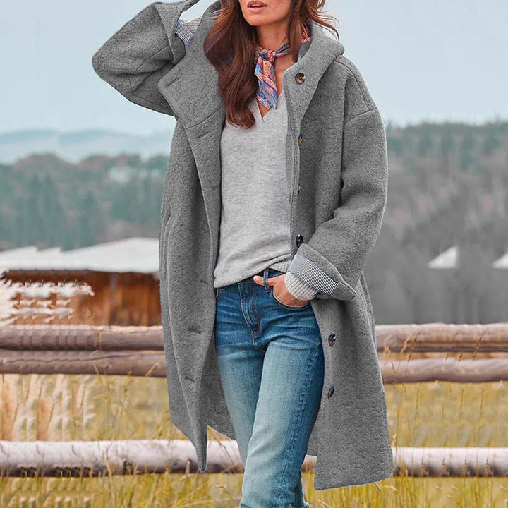 Frau in grauem Wollmantel, Jeans und Schal, Herbstmode, Outdoor, lässiger Stil.