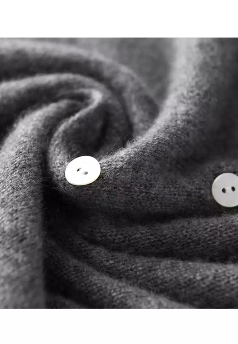 Grauer Wollpullover mit weißen Knöpfen, weiches Material, modisches Design, Herbstmode.