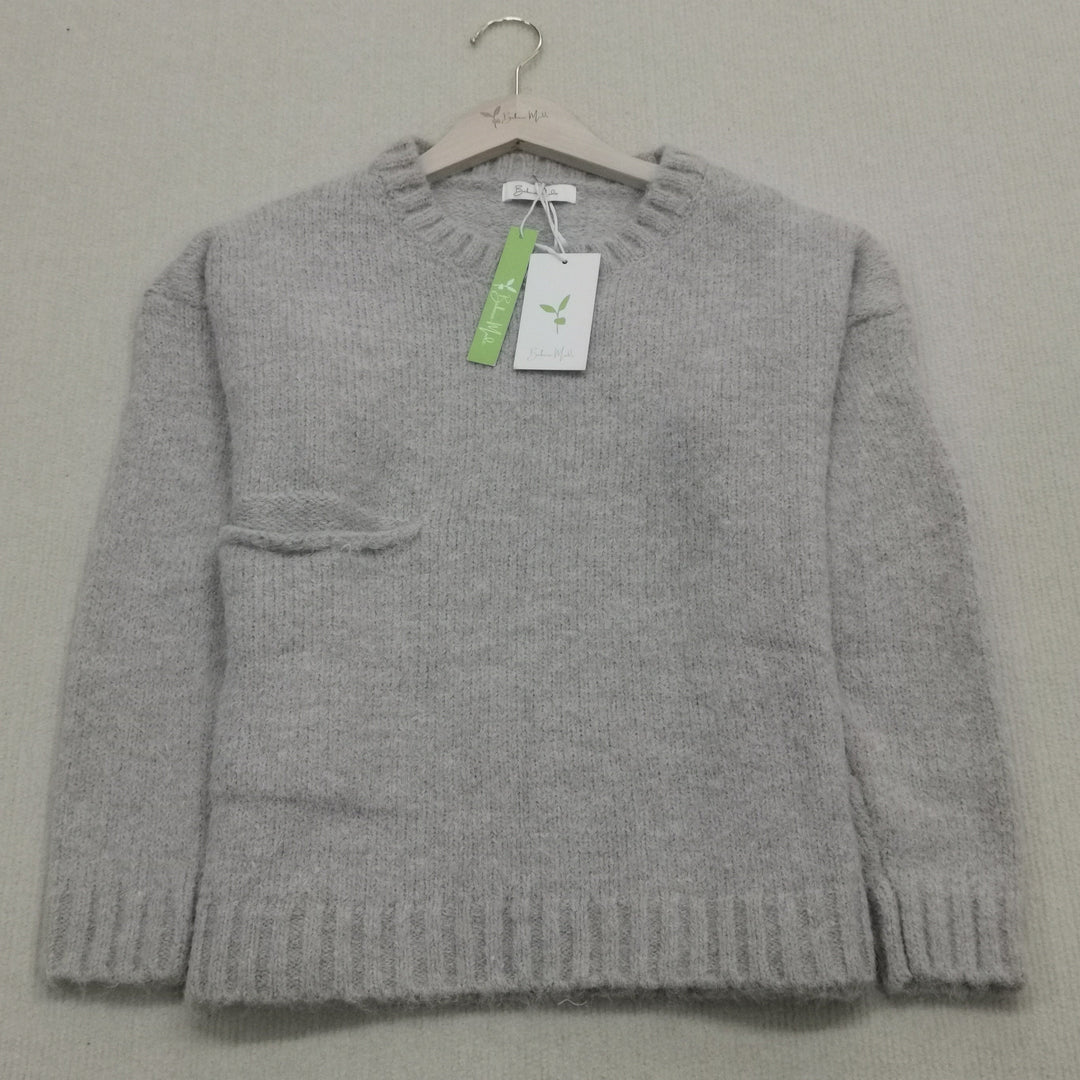 Grauer Wollpullover auf Bügel, Rundhalsausschnitt, Etikett, weiches Material, Damenmode.