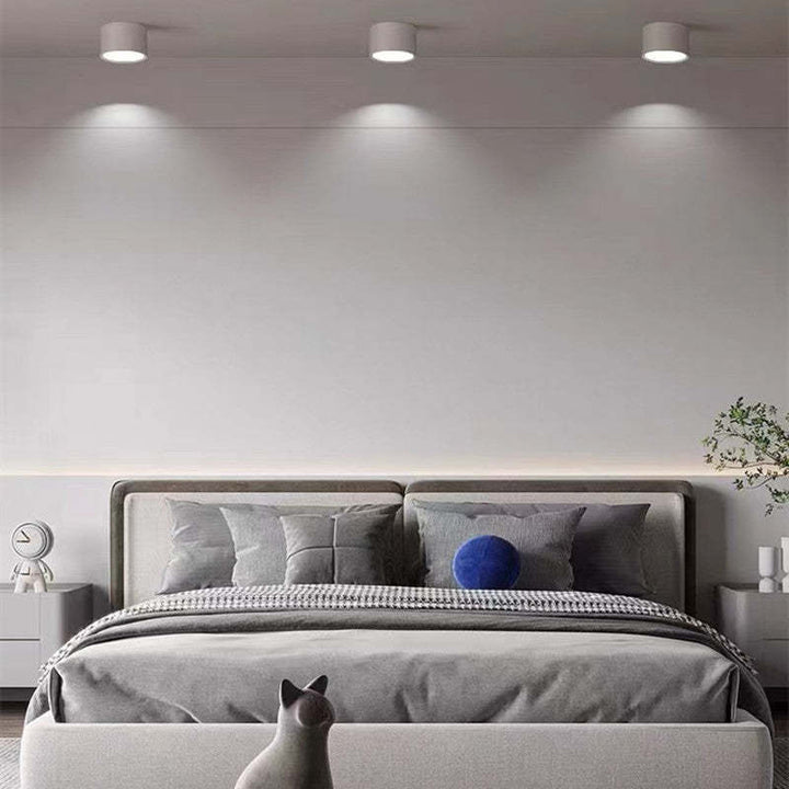 Graues modernes Schlafzimmer mit Doppelbett, grauer Bettwäsche, blauer Kissen, minimalistisches Design.