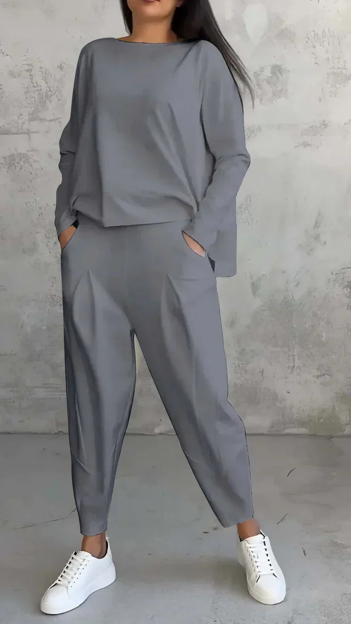Damen-Outfit, grauer Oversize-Zweiteiler, lässig, mit weißen Sneakers, modisch, bequem.