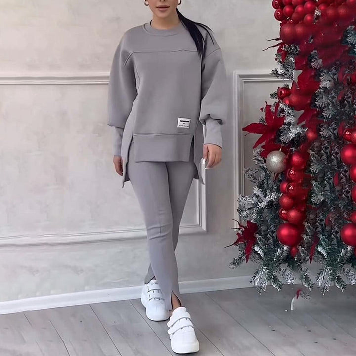 Frau in grauem Trainingsanzug, weiße Sneakers, Weihnachtsdekoration, gemütliche Mode.