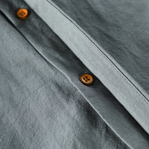 Graues Hemd aus Baumwolle mit braunen Knöpfen, Nahaufnahme, hochwertige Herrenmode.