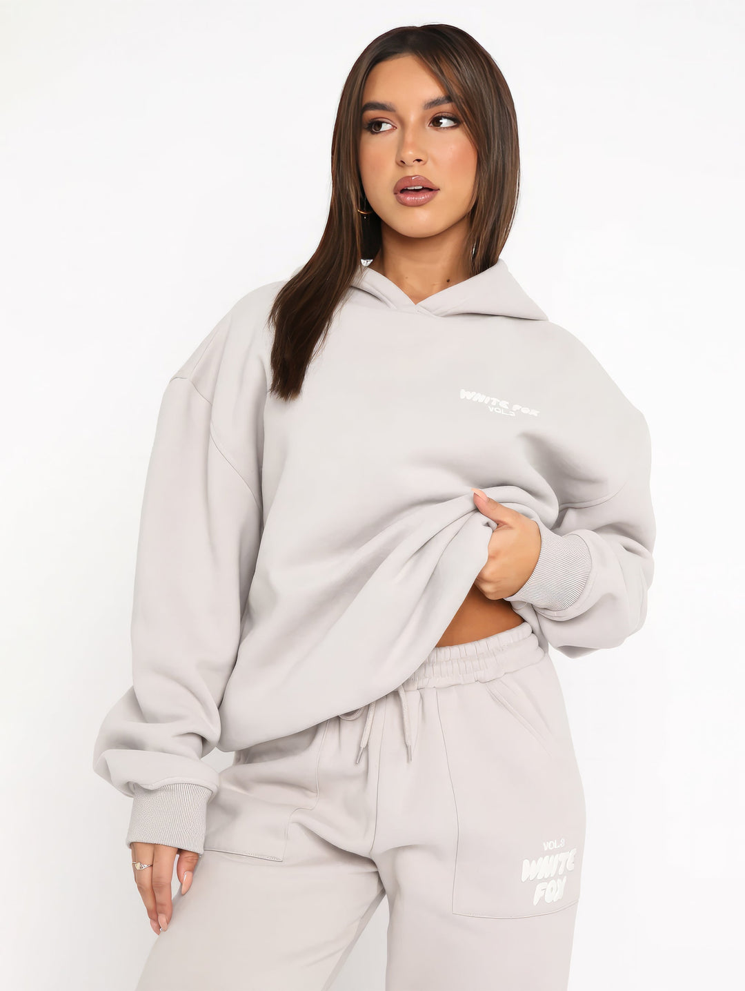 Frau in grauem Hoodie und Jogginghose, lässige Mode, bequeme Freizeitkleidung, Streetwear.