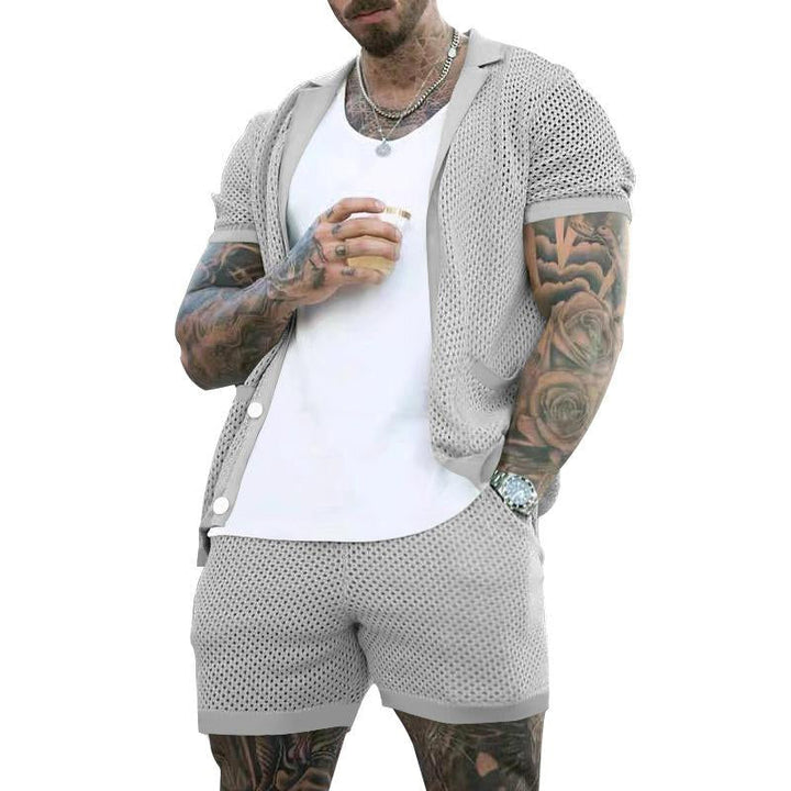 Mann in grauem Netz-Shorts-Set, weißes T-Shirt, tätowiert, Sommermode, Freizeitkleidung.