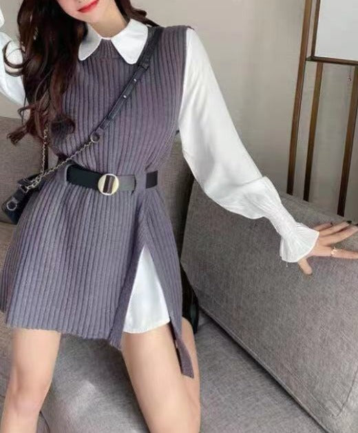 Frau in grauem Strickkleid mit Gürtel und weißer Bluse auf Sofa sitzend.