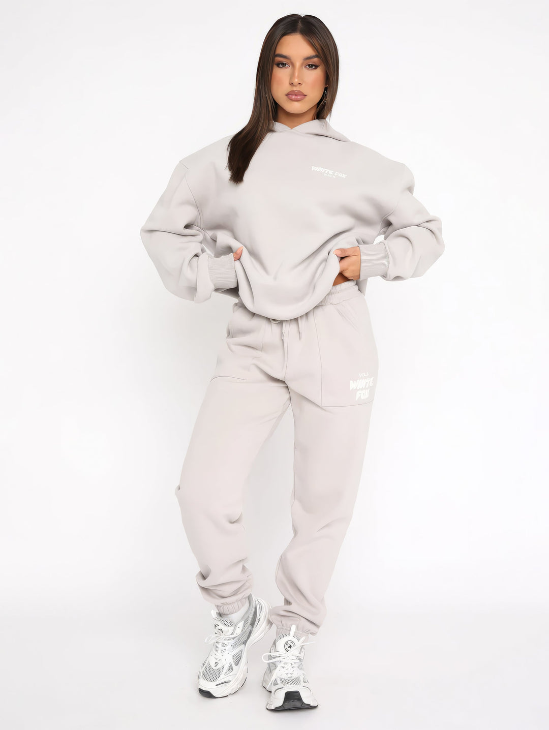 Frau in grauem Hoodie und Jogginghose, sportlich, lässig, Streetwear, Mode, Sneakers.
