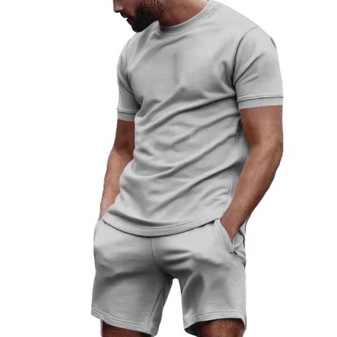 Mann in grauem T-Shirt und Shorts, Freizeitkleidung, Sommermode, Herrenbekleidung.