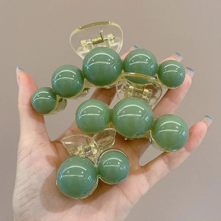 Grüner Haarklammer aus Kunststoff mit Kugeldesign, modisches Accessoire für Damen.