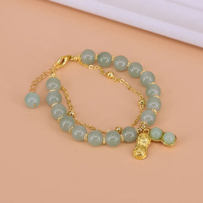 Grünes Jade-Armband mit goldenen Akzenten und Anhänger, eleganter Schmuck für Damen.