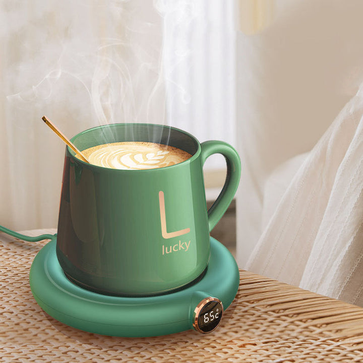 Grüne Tasse mit Latte Art auf Heizplatte, Temperaturanzeige, modernes Design, Kaffeetasse.