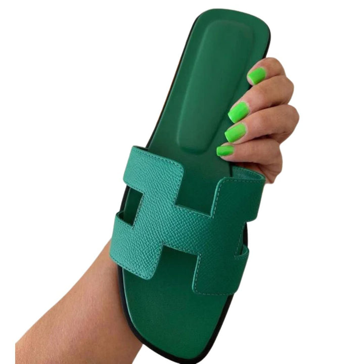 Grüner Lederslipper mit H-Design, Damenmode, handgehalten, modische Sommerschuhe.