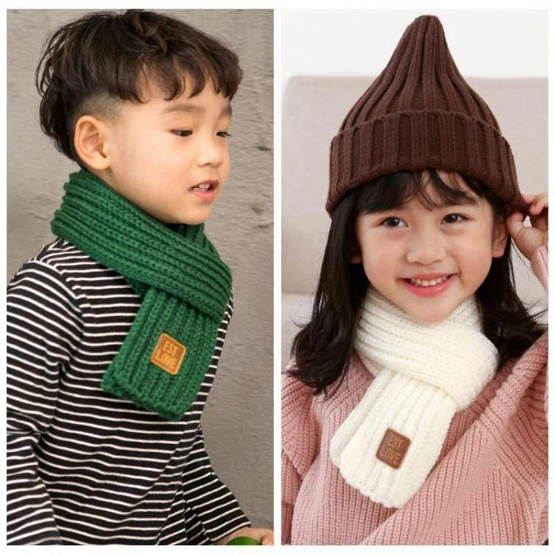 Kinder mit gestricktem Schal und Mütze, grün und weiß, warm, modisch, Winteraccessoires.