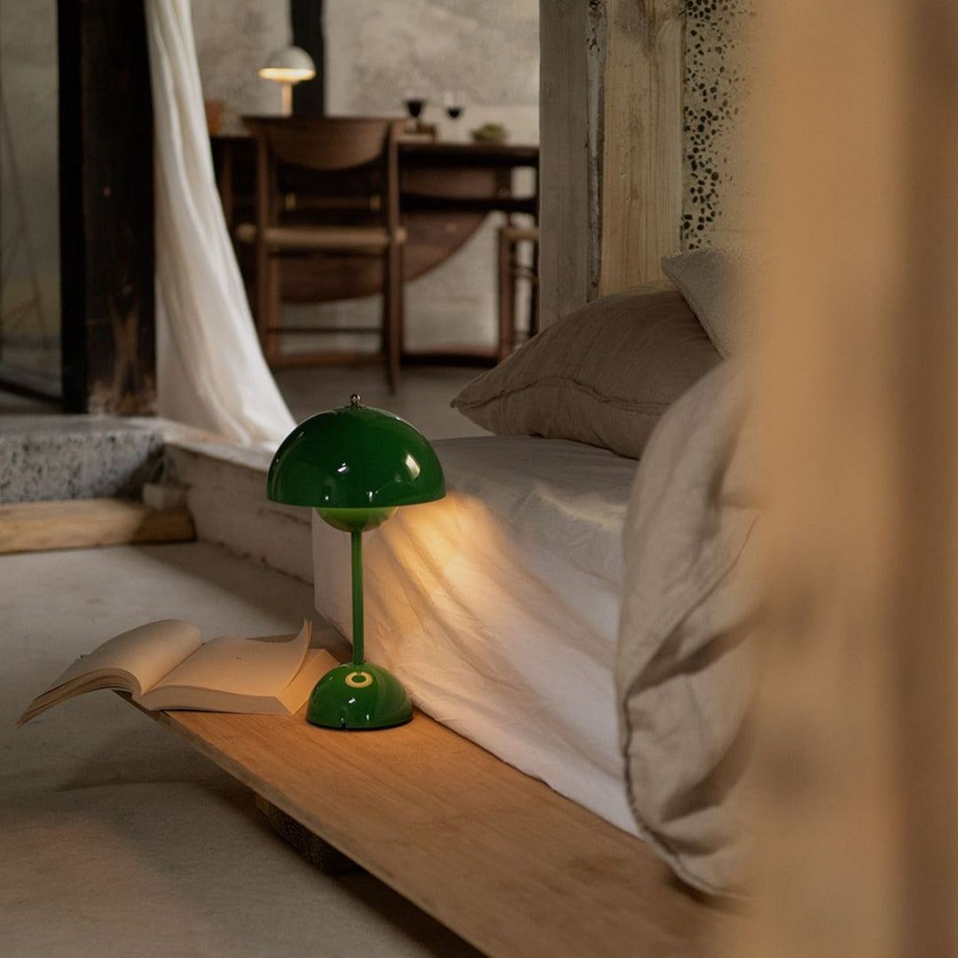 Grüne Tischlampe aus Metall neben Bett, modernes Design, stimmungsvolle Beleuchtung, Schlafzimmer.