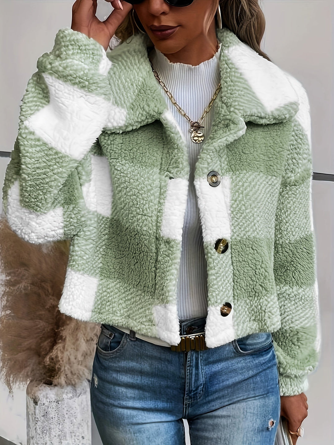 Frau trägt grün-weiß karierte Sherpa-Jacke, Jeans, modisch, Herbstmode, Damenbekleidung.