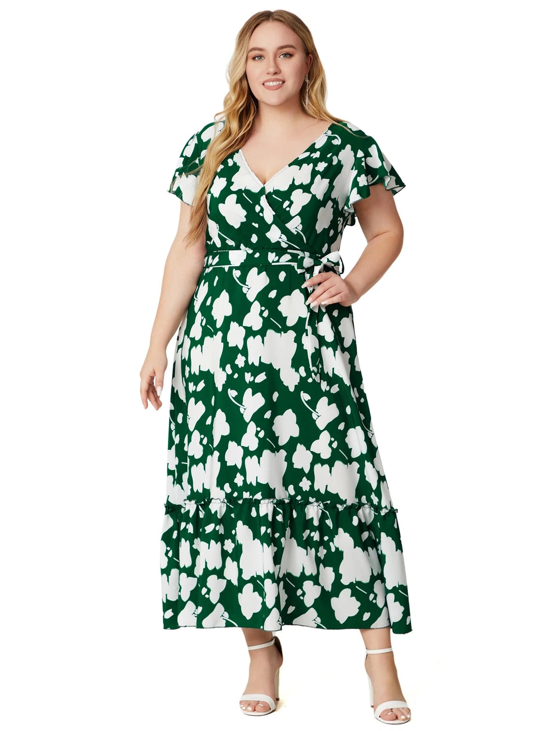 Frau im grünen Maxikleid mit Blumenmuster, V-Ausschnitt, kurze Ärmel, Plus-Size-Mode.