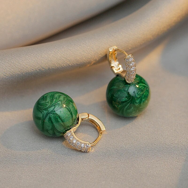 Grüne Ohrringe mit goldenen Details und Strasssteinen, eleganter Schmuck für Damen.