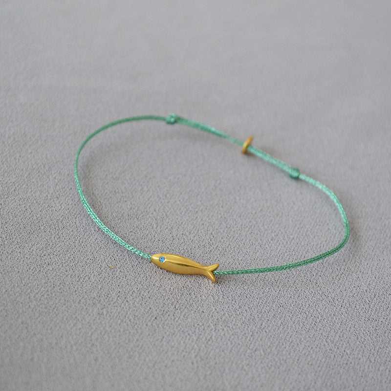 Grünes Armband mit gelbem Fischanhänger, minimalistisches Design, Schmuck für Damen.