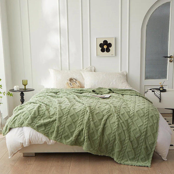 Grünes Strickplaid auf weißem Bett, modernes Schlafzimmer, skandinavisches Design, gemütlich.