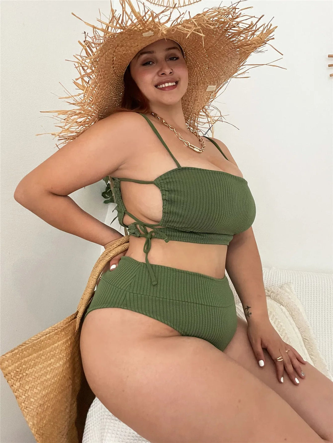 Frau im grünen Bikini mit Strohhut und Tasche, Sommermode, Strandkleidung, lächelnd.
