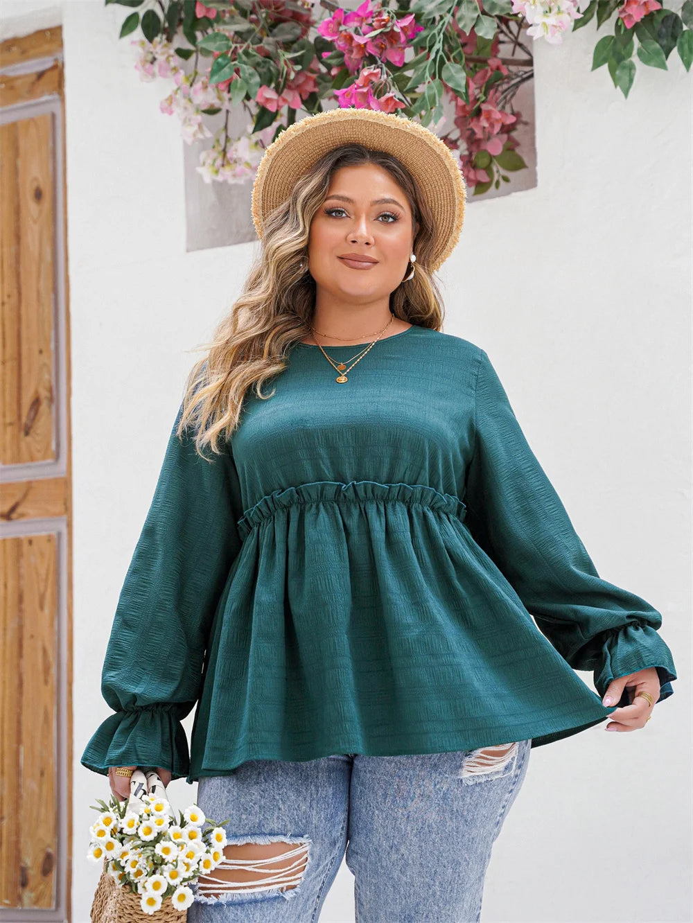 Frau in grüner Bluse und Jeans, Strohhut, Blumenstrauß, lächelnd, draußen, Sommermode.