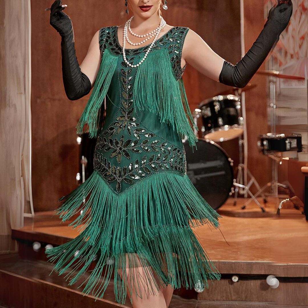 Frau im grünen Fransen-Kleid, schwarze Handschuhe, Retro-Mode, Vintage-Stil, Bühne im Hintergrund.