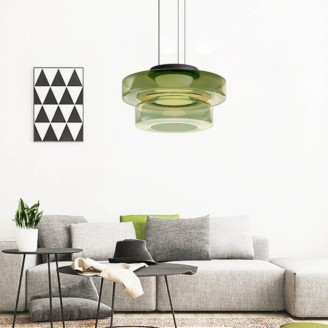Grüne Glas-Pendelleuchte über modernem grauen Sofa in minimalistischem Wohnzimmer.