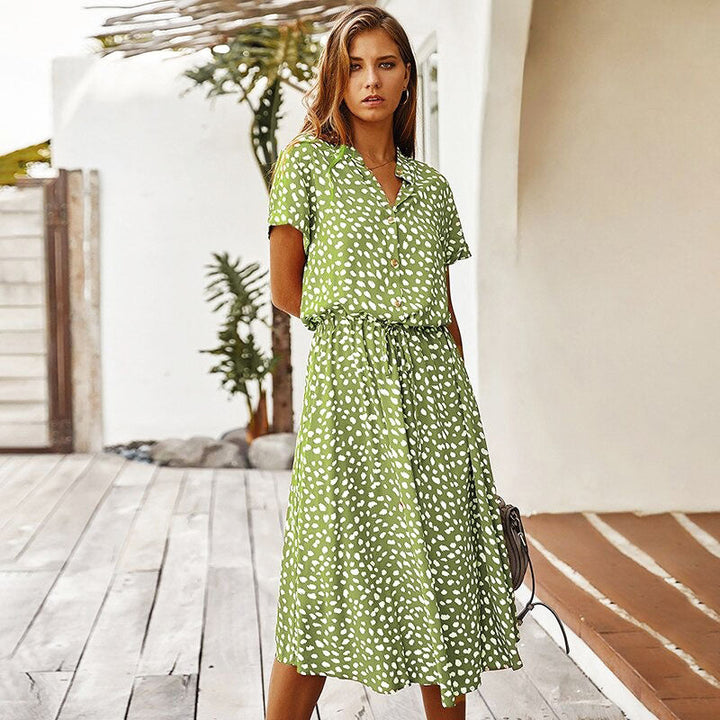 Frau in grünem gepunktetem Sommerkleid auf Terrasse, lässige Mode, Damenbekleidung.