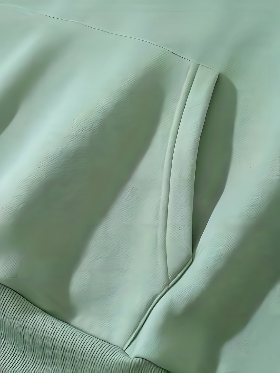 Grüne Lederjacke Detailansicht, weiches Material, modisches Design, hochwertige Verarbeitung.
