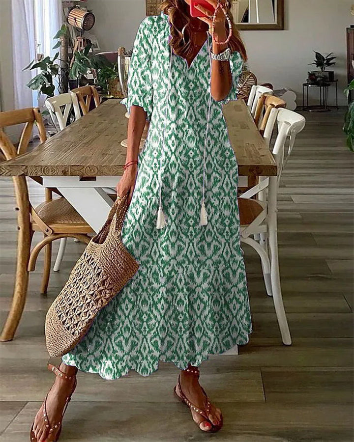 Frau in grünem Boho-Kleid mit Korbtasche, Sommermode, lässiger Stil, Esszimmer im Hintergrund.