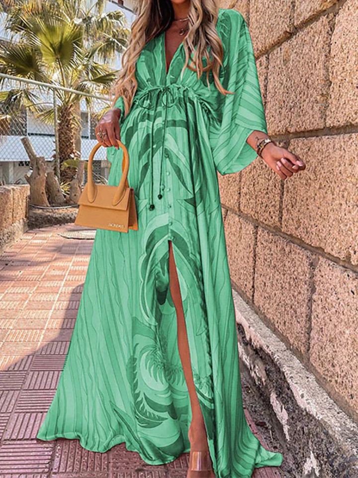 Frau in langem, grünem Maxikleid mit Muster, hält gelbe Handtasche, Sommermode.