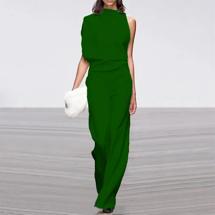Frau in grünem Abendkleid mit weißer Clutch auf Laufsteg.