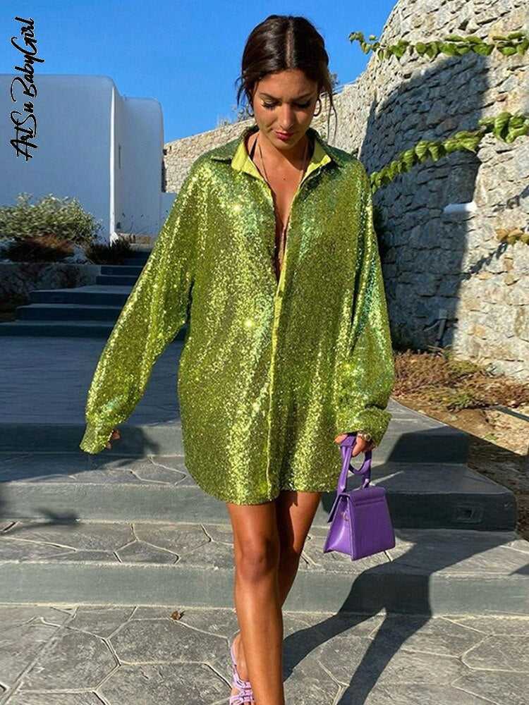 Frau in grünem Paillettenhemd, lila Tasche, Sommermode, eleganter Look, Outdoor-Hintergrund.