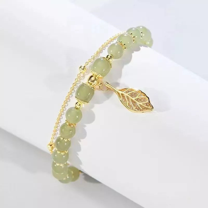Grünes Jade-Armband mit goldfarbenem Blattanhänger, eleganter Schmuck für Damen.