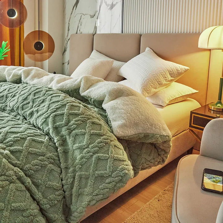 Grünes Bettdecke-Set aus Fleece auf einem modernen Bett mit Kissen, Nachttisch und Lampe.