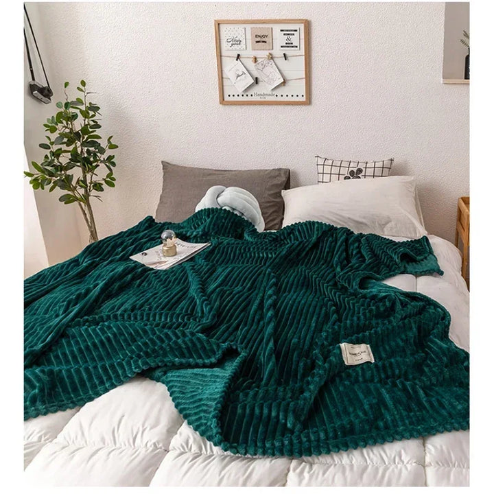Grüne gerippte Decke auf weißem Bett, gemütliches Schlafzimmer, moderne Inneneinrichtung.