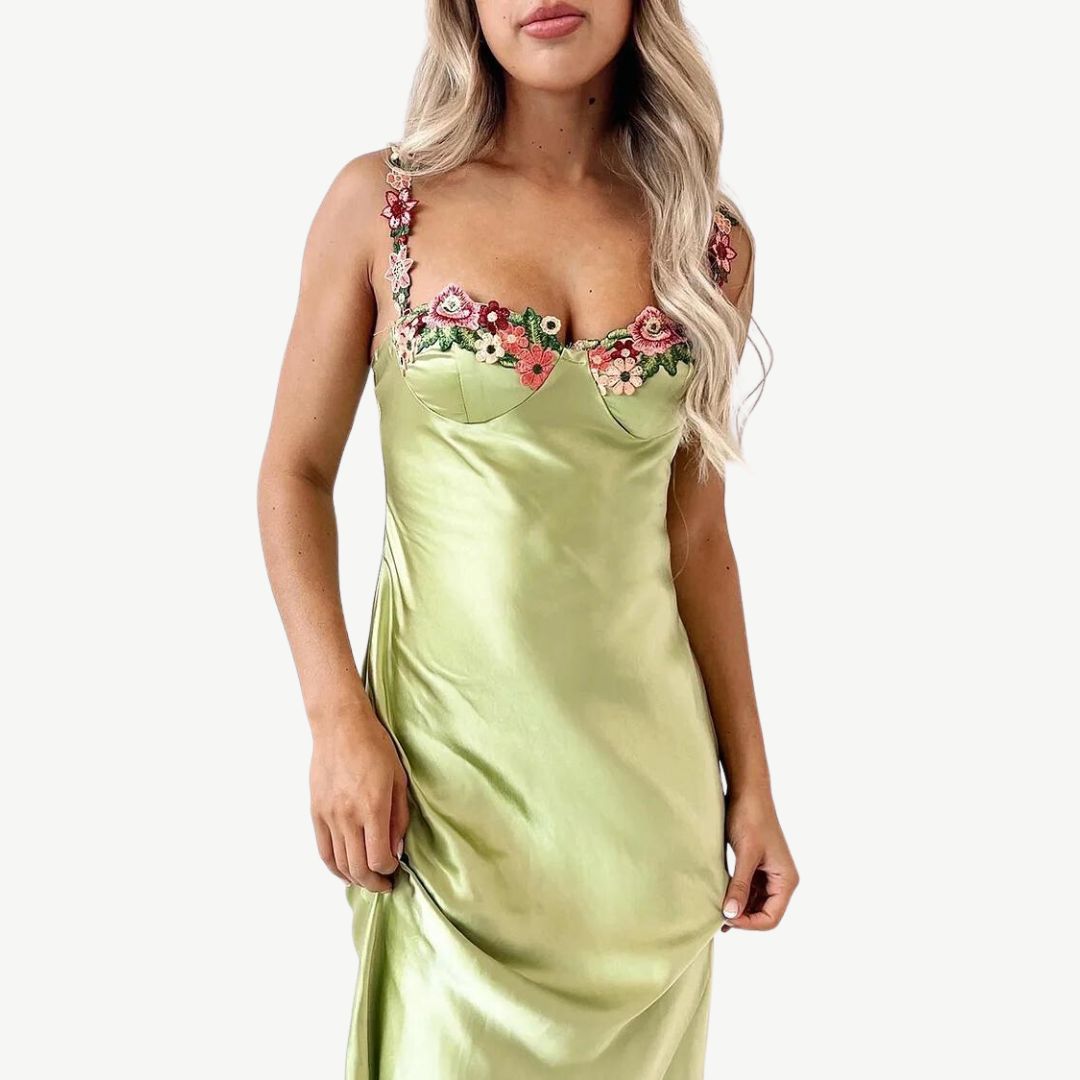Frau in grünem Satin-Slip-Kleid mit Blumenstickerei, elegantes Abendkleid, modisch.