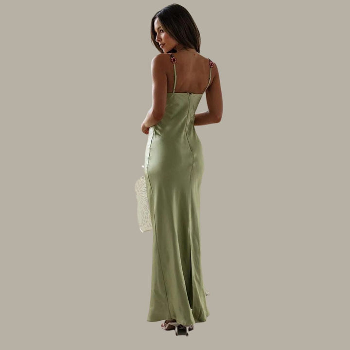 Frau in grünem Satin-Slip-Kleid, elegantes Abendkleid, Spaghettiträger, Rückansicht.