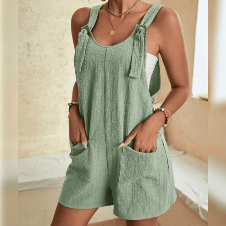 Frau in mintgrünem Jumpsuit aus Baumwolle, Sommermode, lässiger Stil, ärmellos, Taschen.