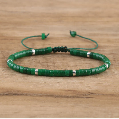 Grünes Perlenarmband aus Jade mit verstellbarem Verschluss auf Holzoberfläche.