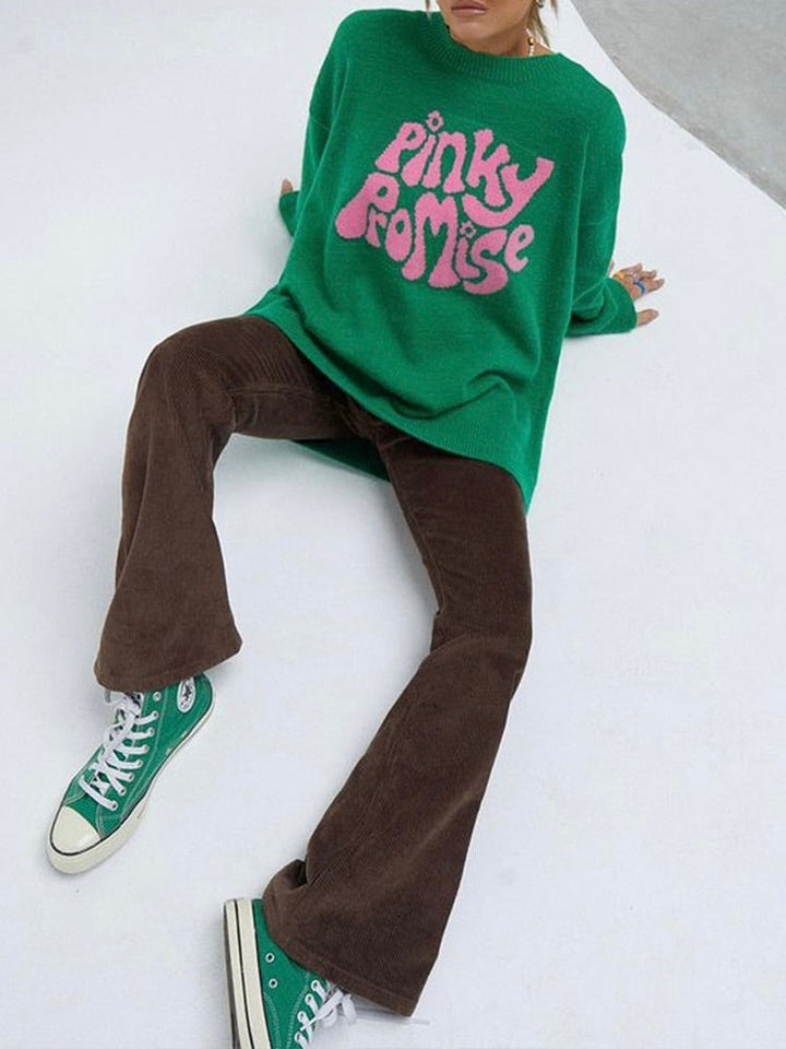 Grüner Pullover mit "Pinky Promise"-Aufdruck, braune Cordhose, grüne Sneakers.