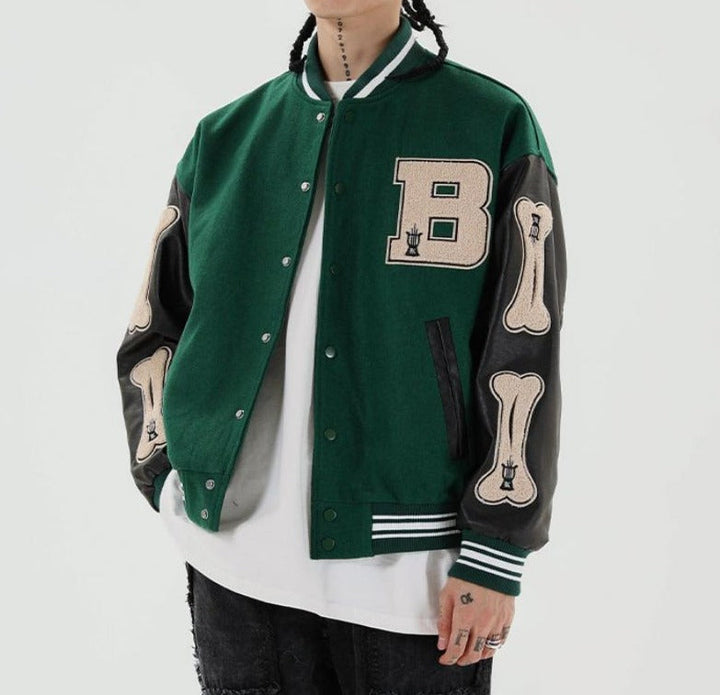 Grüne Collegejacke mit Lederärmeln, Buchstaben- und Knochenapplikationen, Unisex-Mode.